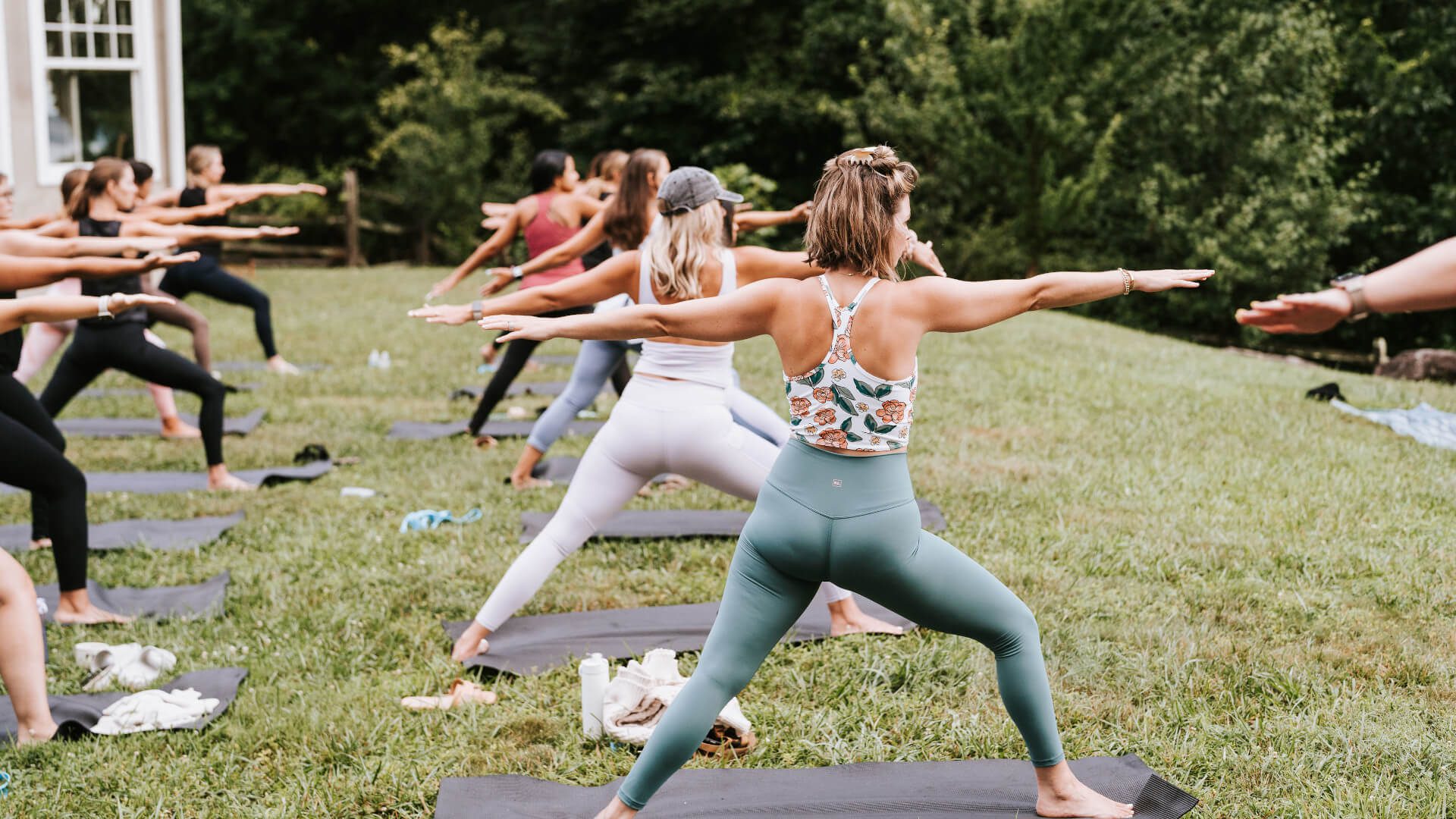 A dozen women practicing yoga outside a private residence during a private yoga session from Asheville Wellness Tours.