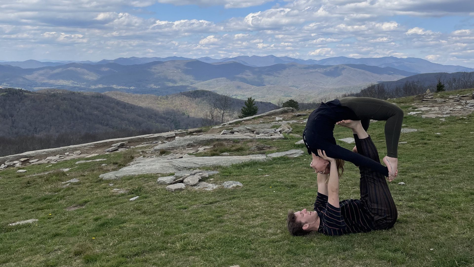 Couple doing yoga on top of an Asheville Mountain while on a Couples Retreat.