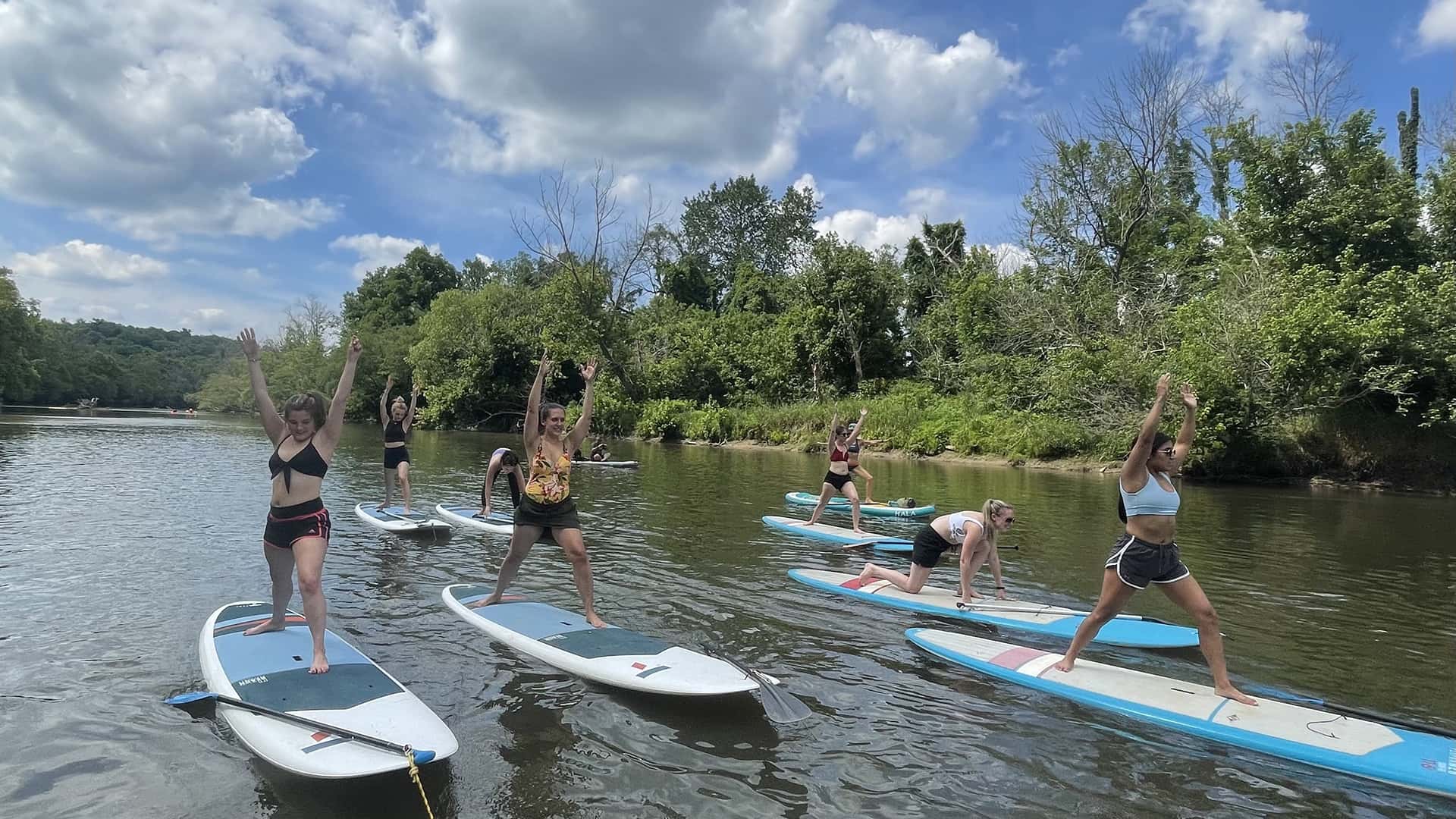 Bachelorette party participating in in a SUP yoga class along the French Broad River in Asheville, NC.
