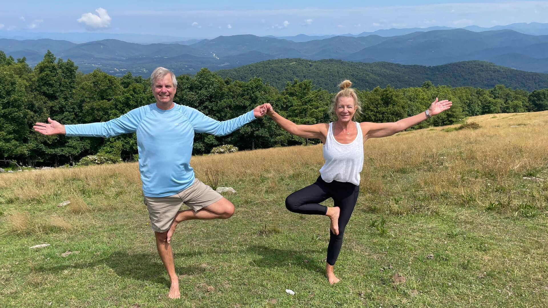Couple doing yoga together during Couples Retreat yoga session on an Asheville mountain.